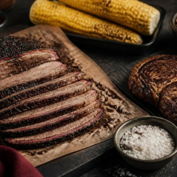 Father's Day barbecue spread with sliced brisket, ribeye and grilled corn