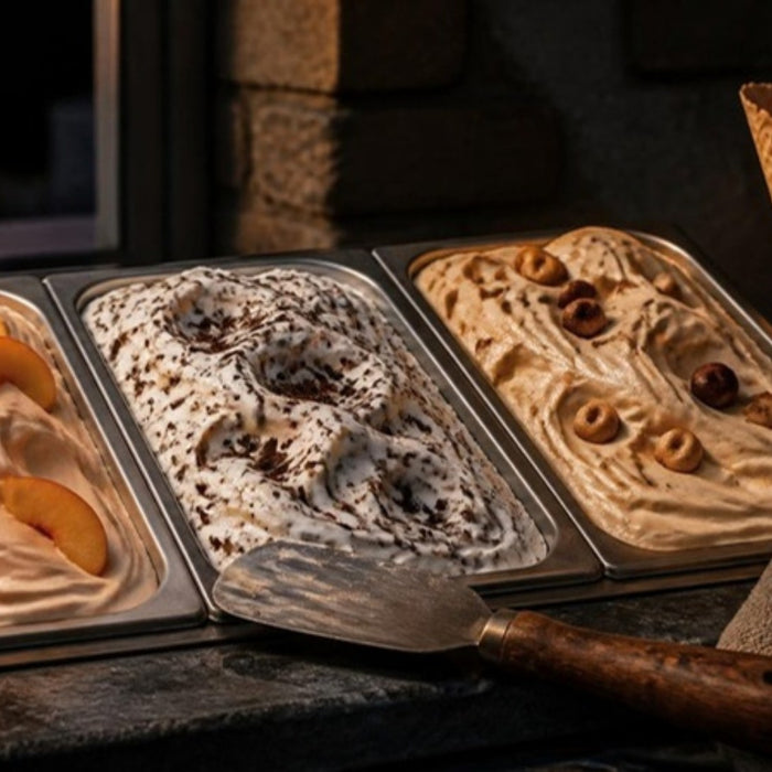 Gelato pans of peach, stracciatella and hazelnut with waffle cones