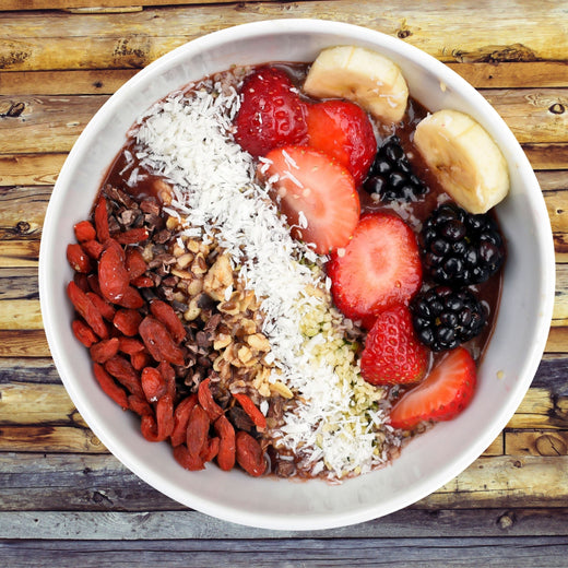 Açaí bowl topped with goji berries, cacao nibs, granola, coconut, hemp seeds, strawberries, blackberries and banana